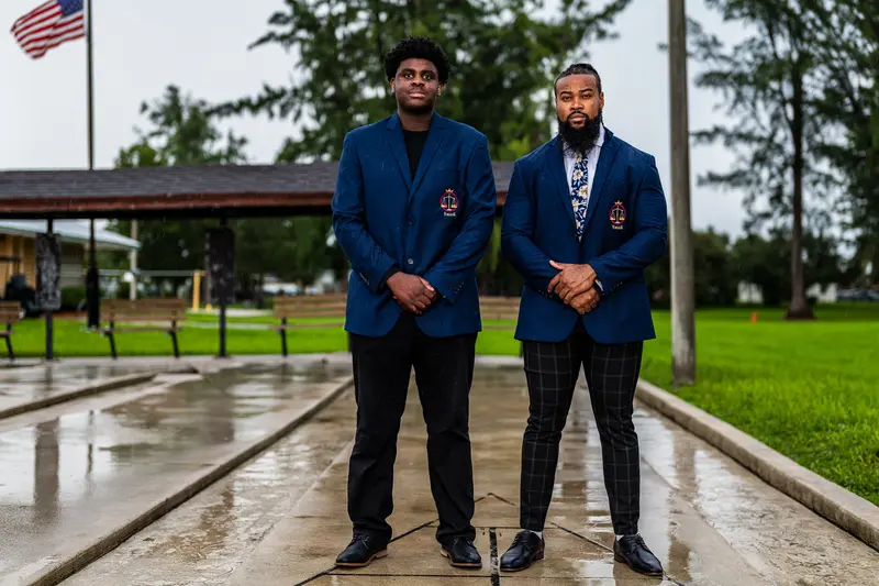 Two community leaders in matching blazers standing together