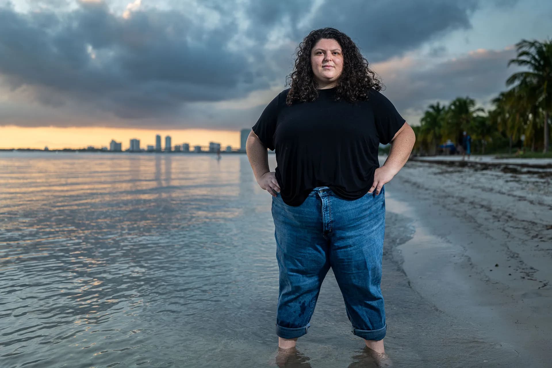 Woman standing on Miami shoreline at sunset